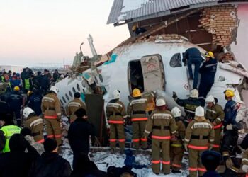 In this handout photo provided by the Emergency Situations Ministry of the Republic of Kazakhstan, police and rescuers work on the side of a plane crash near Almaty International Airport, outside Almaty, Kazakhstan, Friday, Dec. 27, 2019. Almaty International Airport said seven people died on Friday in the crash of a Bek Air plane in Kazakhstan. The aircraft had 100 passengers and crew abroad, and hit a concrete fence and a two-story building shortly after takeoff. ( Emergency Situations Ministry of the Republic of Kazakhstan photo via AP)