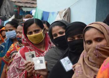 KHARDA, APR 22 (UNI):- Voters showing their voter's identity cards while waiting in a queue  for their turn to cast their votes for the West Bengal Assembly election at a polling booth at Kharda in North 24 Pargana district on Thursday. UNI PHOTO-VKY1U