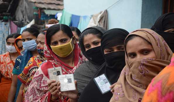 KHARDA, APR 22 (UNI):- Voters showing their voter's identity cards while waiting in a queue for their turn to cast their votes for the West Bengal Assembly election at a polling booth at Kharda in North 24 Pargana district on Thursday. UNI PHOTO-VKY1U