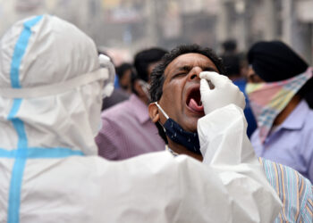 New Delhi, Nov 04 (ANI): A health worker in personal protective equipment (PPE) collects a swab sample from a man at the Sadar Bazar market to conduct tests for the coronavirus disease (COVID-19), in Delhi on Wednesday. (ANI Photo)