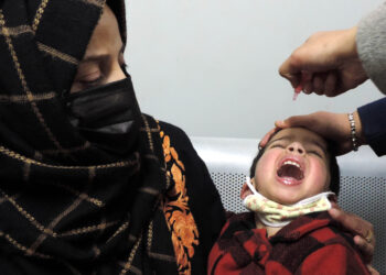 SRINAGAR, FEB 27 (UNI):- A health worker administering polio vaccine to a child at SMHS Hospital in Srinagar on Sunday during pulse polio immunization programme. UNI PHOTO-38U