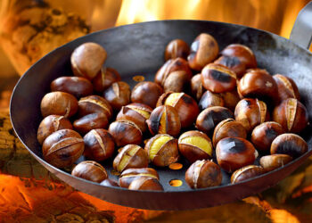 Roasting chestnuts in a special pan over an open fire